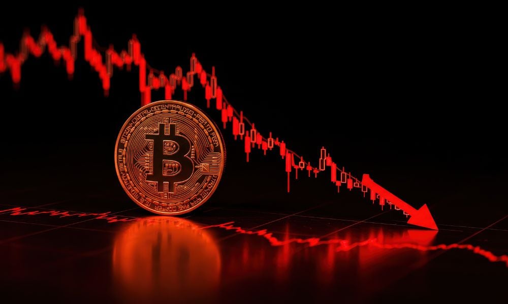 Gold Bitcoin and silver Ethereum coins resting on a laptop keyboard before a trading chart