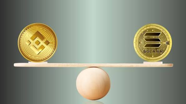 Gold Bitcoin and silver Ethereum coins resting on a laptop keyboard before a trading chart